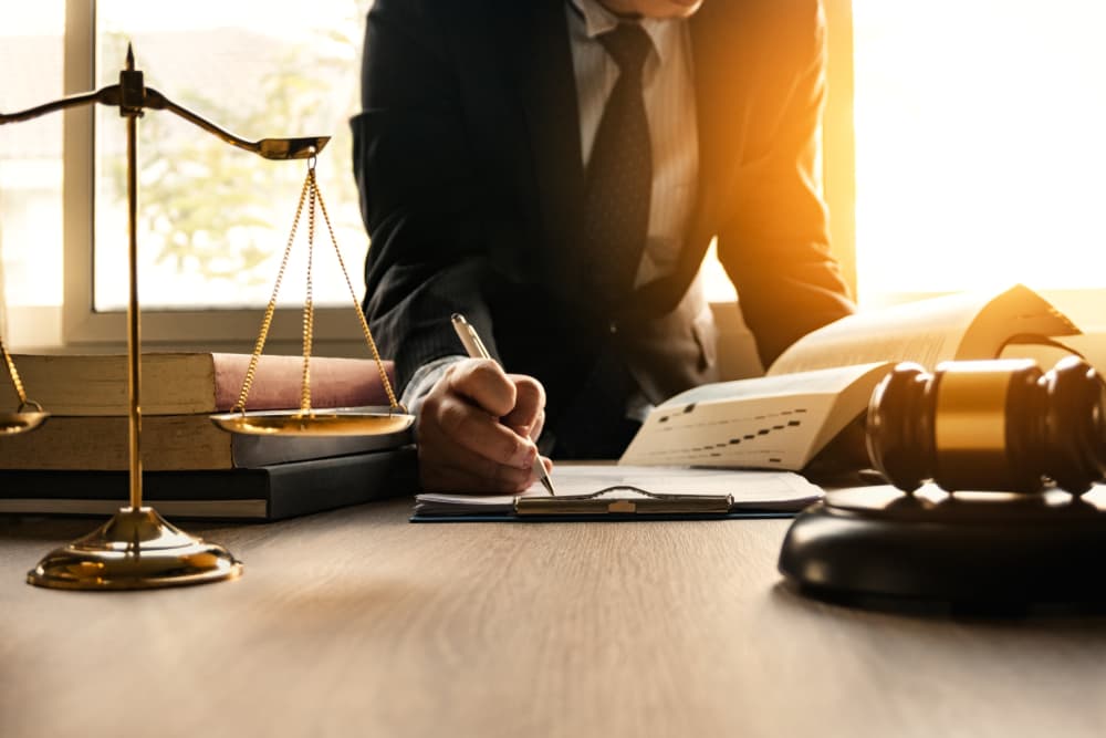 Lawyer reviewing contract papers with gavel on table in courtroom - legal concept