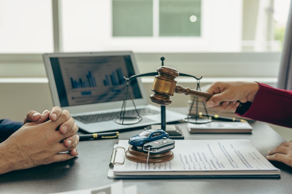 A meeting with lawyer, gavel, scales of justice, and legal documents displayed.